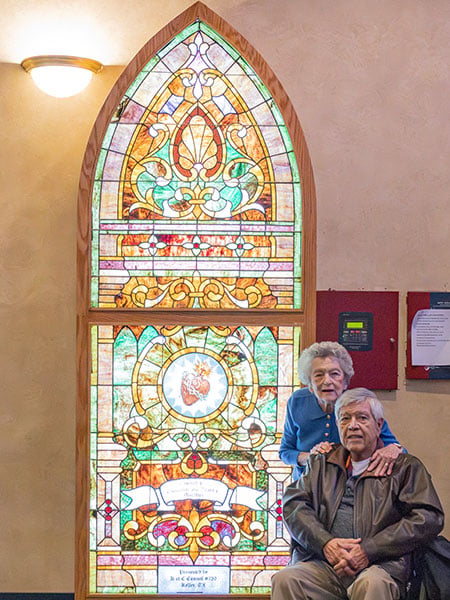 man and woman by stained glass window
