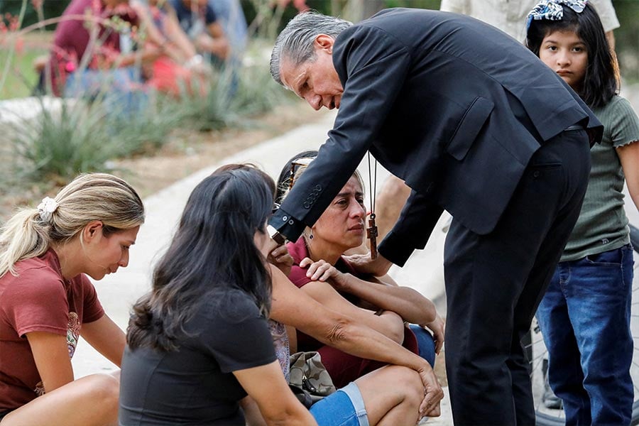 Archbishop Gustavo García-Siller of San Antonio comforts people in Uvalde outside the SSGT Willie de Leon Civic Center, where students had been transported from Robb Elementary School after a shooting May 24, 2022. (CNS photo/Marco Bello, Reuters)