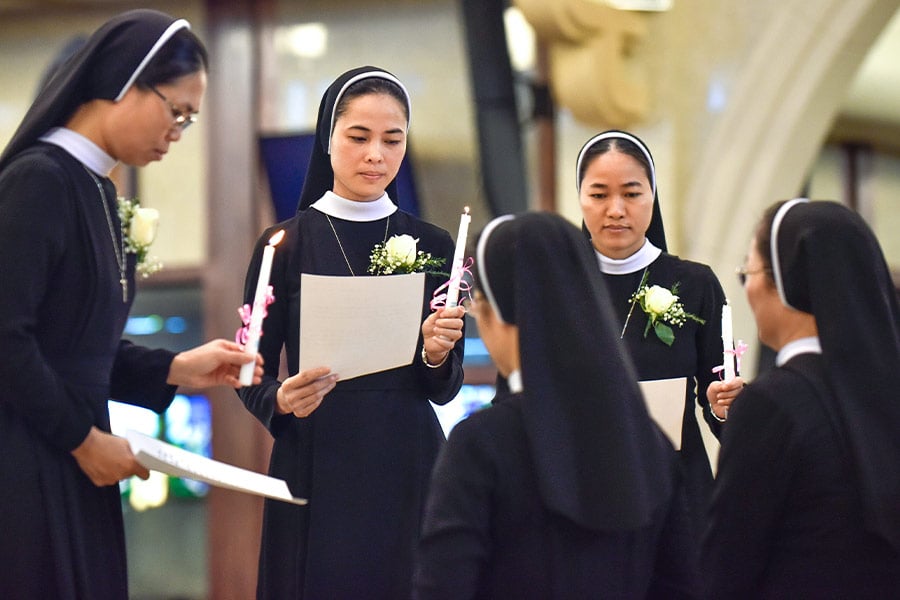 Three sisters, of a group of nine from the Lovers of the Holy Cross order, renew their vows at Vietnamese Martyrs Parish in Arlington Aug. 11, 2019. (NTC/Ben Torres)