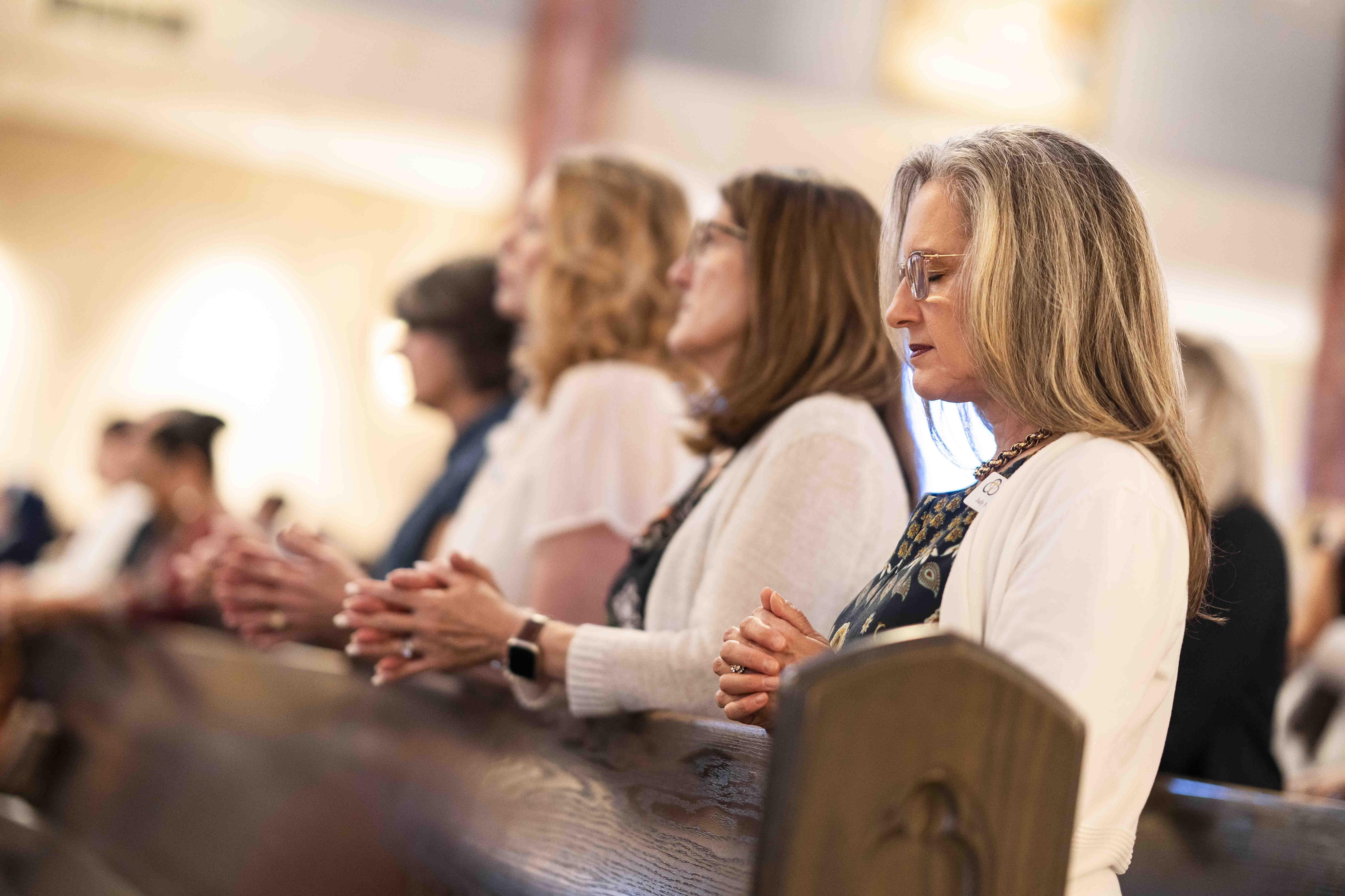 teachers praying at a pew