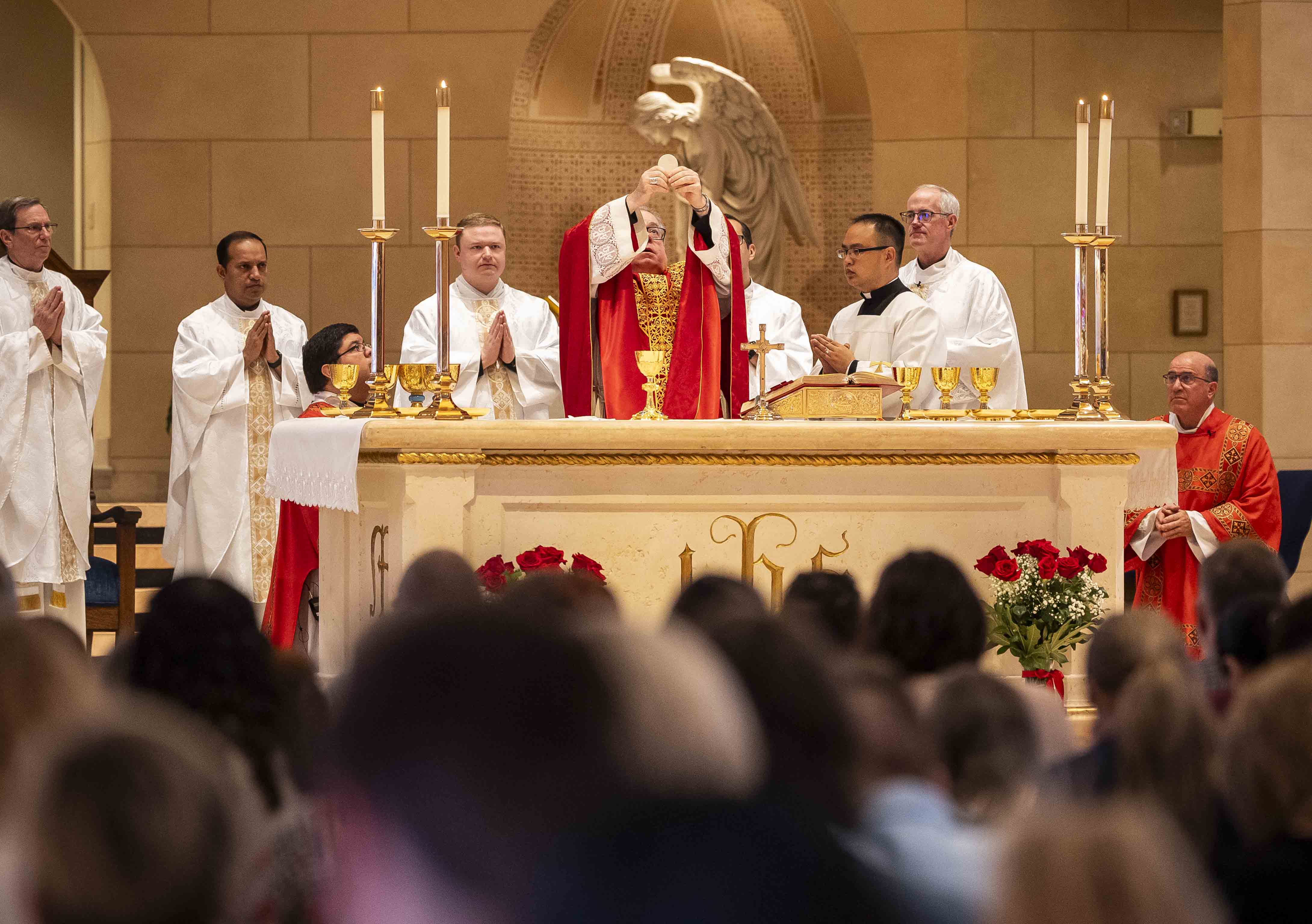B.Olson presents the Eucharist during Mass