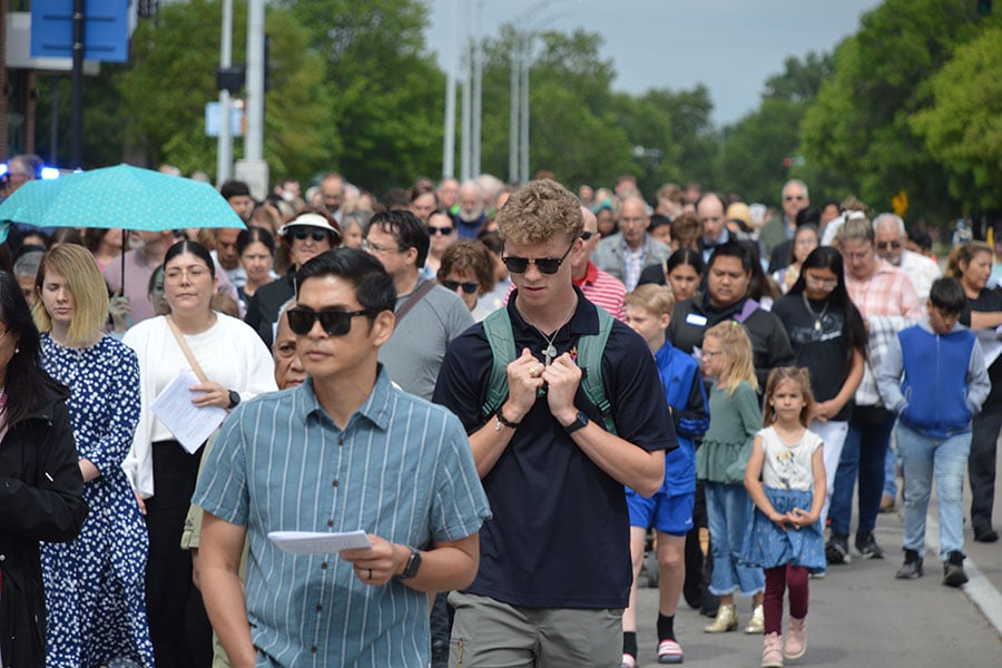 Hundreds of faithful walk towards the camera during a procession on the street