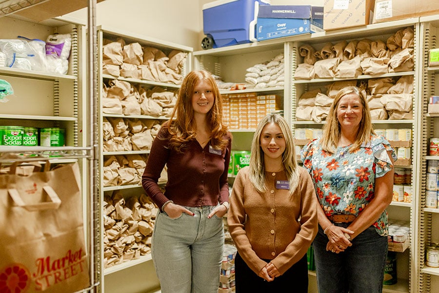 Catholic Charities Fort Worth staff Taylor Mull, Liliana Huerta, and Rita Gauthier stand in the food pantry at CCFW’s Northwest office.  (NTC/Bertha Salazar)