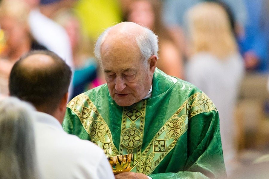Fr. Hawkins offers the blood of Christ to a parishioner during Mass
