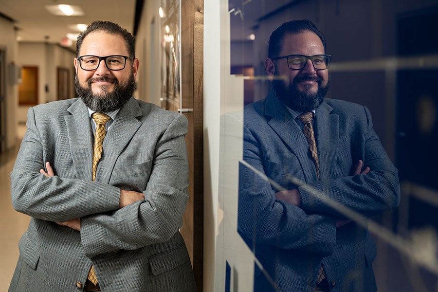 Frank Perez stands against a wall