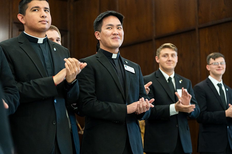 four seminarians clap