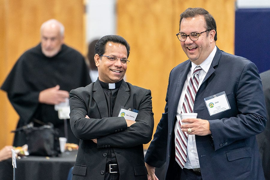 Father John Antony Perikomalayil, HGN, pastor of St. Mary of the Assumption Parish in Fort Worth, shares a laugh with Clint Weber, president of the Advancement Foundation, during the Light of Christ Parish Stewardship Awards on June 24, 2023 at Holy Family Church.