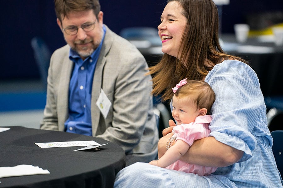 Light of Christ recipient Jill Foley shares a laugh as she holds her baby daughter during the Light of Christ Parish Stewardship Awards on June 24, 2023 at Holy Family Church