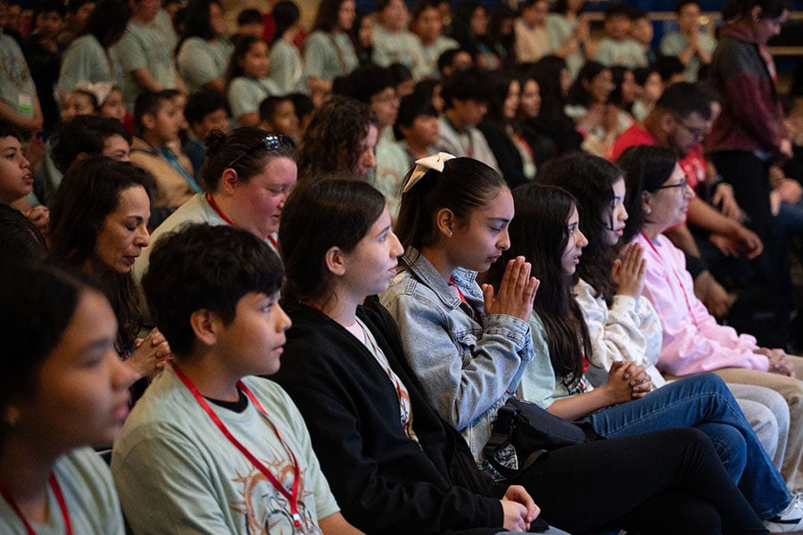 Cinthya Hernandez, of St. Ann Parish in Burleson, holds her hands together for prayer during a middle school rally at Nolan Catholic High School in Fort Worth, on Saturday, Feb. 14, 2026. The rally is an opportunity for middle school youth and their adult leaders from the Diocese to spend a day together in celebration of their Catholic faith and identity.  (NTC/Ben Torres)