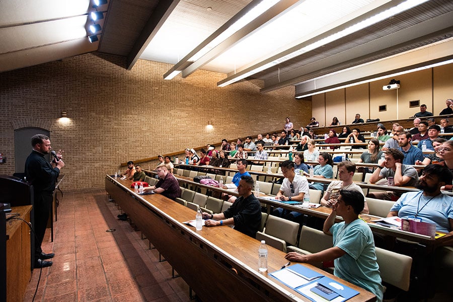 Father Brett speaks to a conference room of young adults