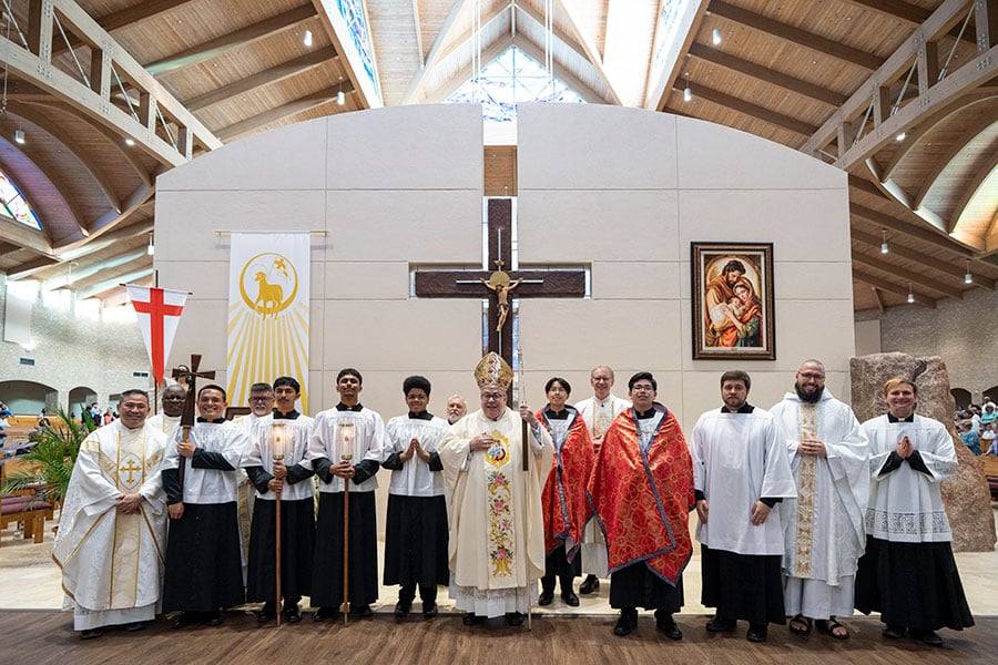 Bishop Olson and priests and altar servers in a line before the cross