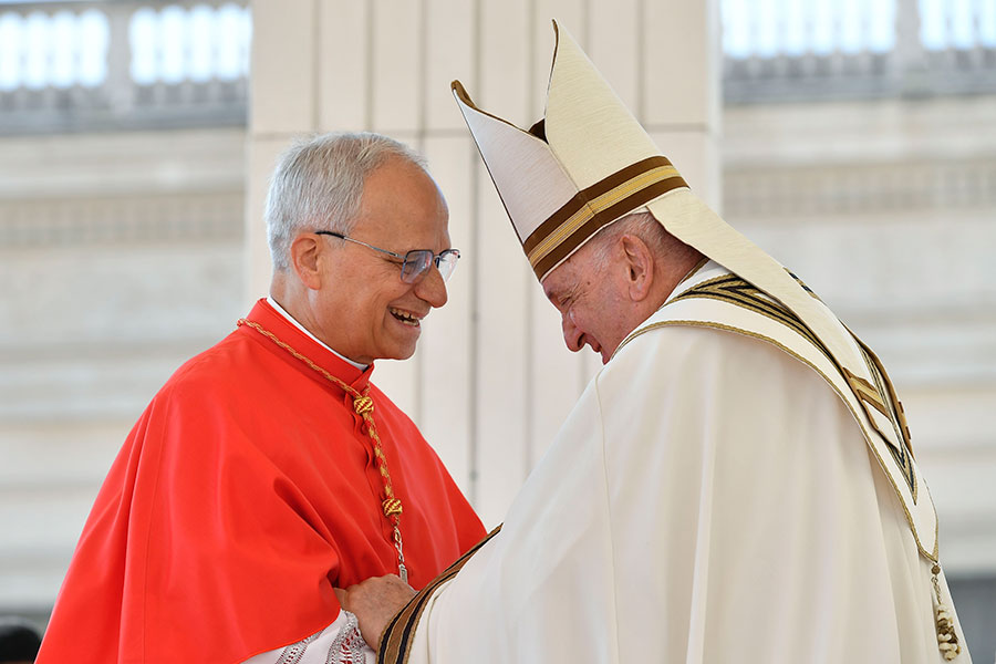 Pope Francis hands U.S. Cardinal Robert Prevost, prefect of the Dicastery for Bishops, a copy of "Spes Non Confundit," ("Hope Does Not Disappoint"), his document proclaiming the Holy Year 2025, during a ceremony in front of the Holy Door of St. Peter's Basilica at the Vatican May 9, 2024. (CNS photo/Lola Gomez)