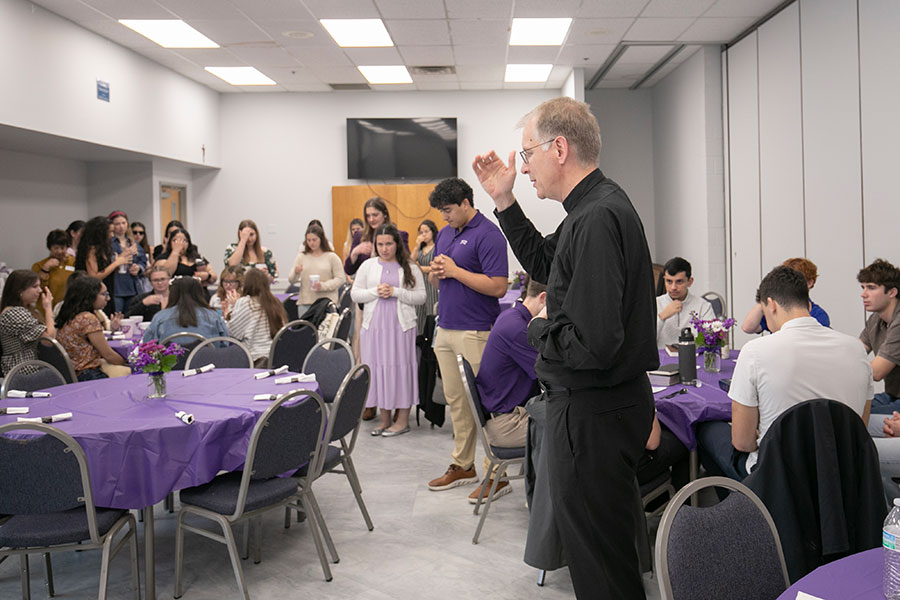 Fr. Johathan Wallis blesses the food after the second annual Purple Mass for TCU students and alumni at Holy Family Catholic Church, Saturday, March 7, 2026. (NTC/Rodger Mallison)