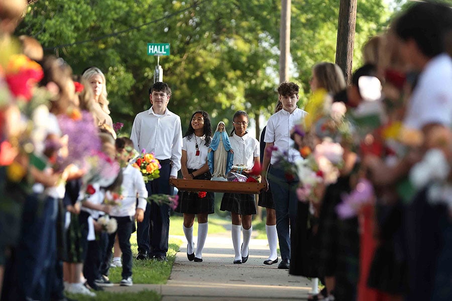 students bear a statue of Mary