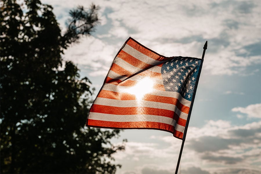 American flag with light formed like cross