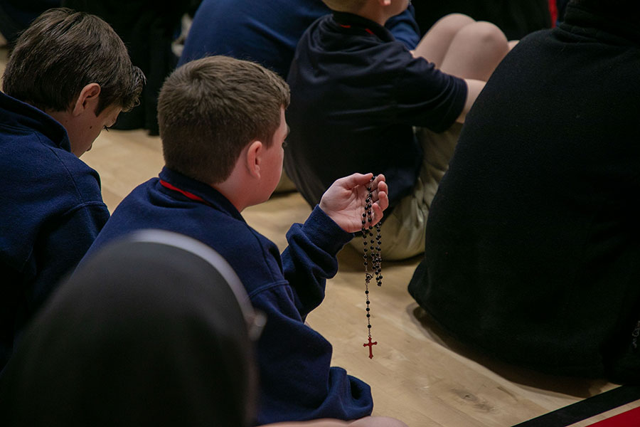 a boy holds a rosary