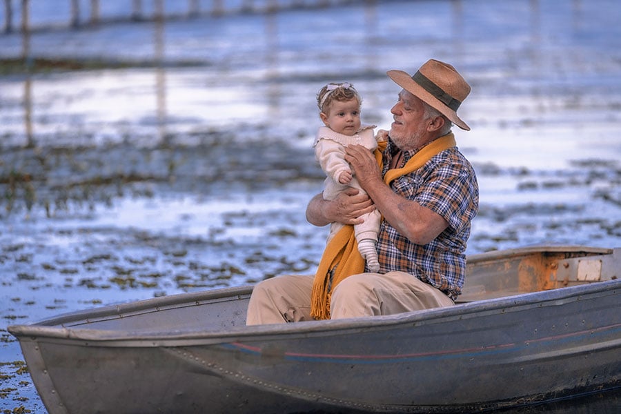 A grandfather with his baby granddaughter on a boat 