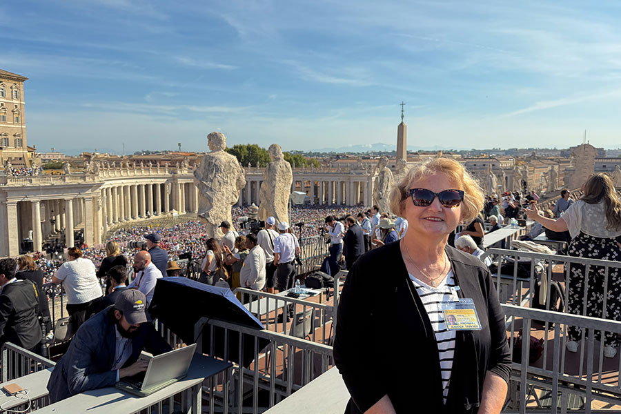 Sharon Perkins stands before a large crowd in front of St. Peter's Square in the Vatican
