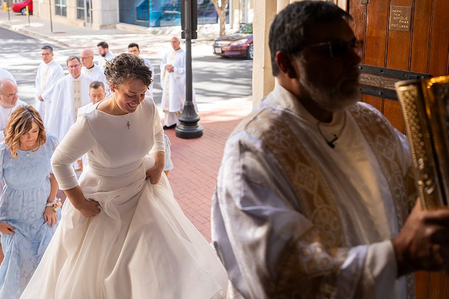 Mary Del Olmo, resplendent in white, walks into the cathedral