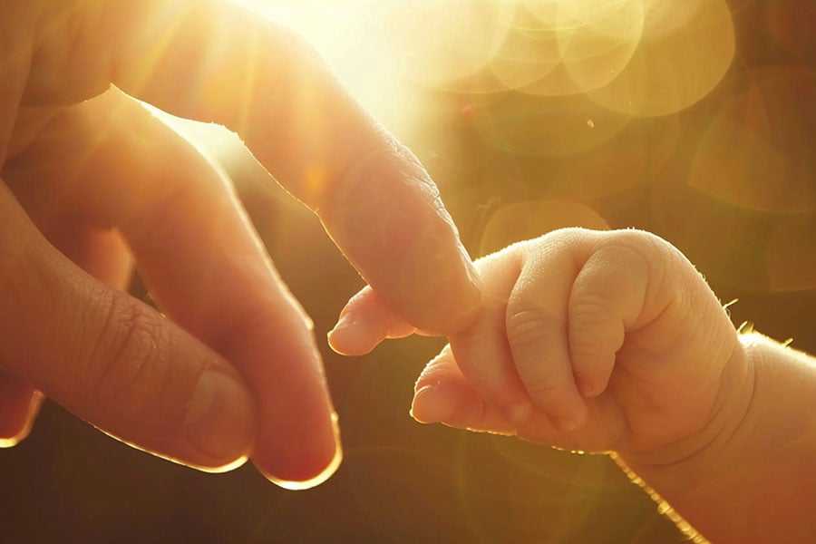 mother holding baby hand