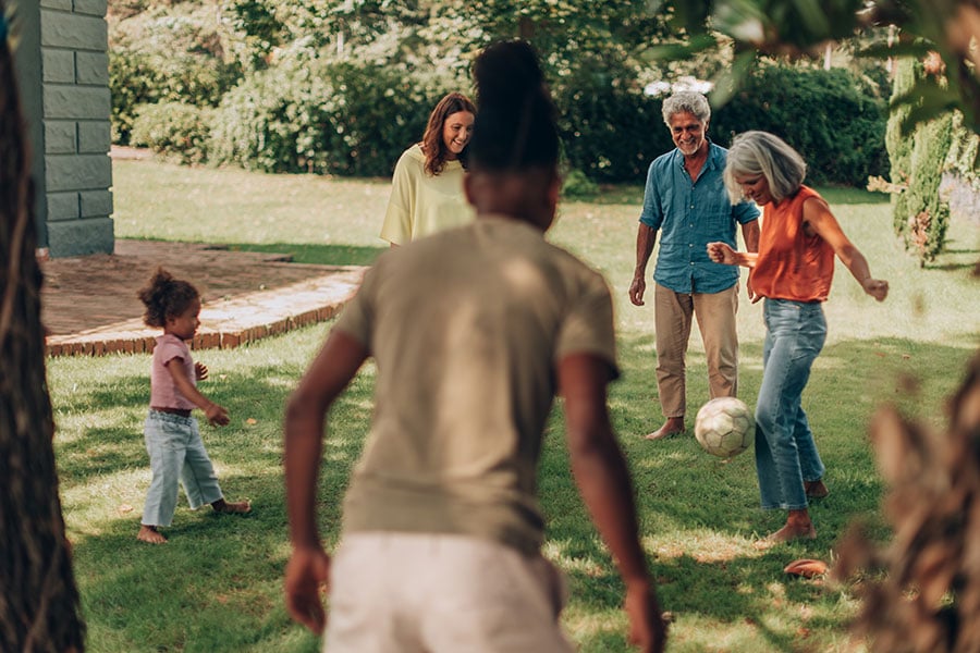 Grandparents play soccer with grandkids