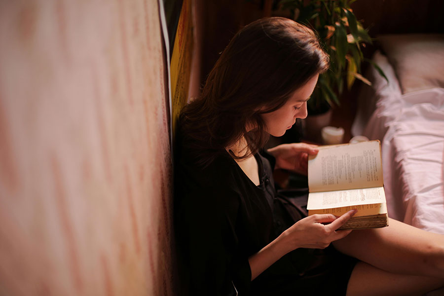 girl sitting on floor reading bible