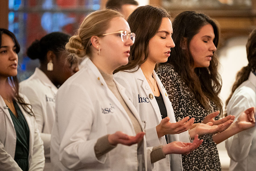 people in white coats praying